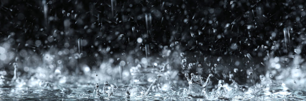 heavy rain with water splashing against a dark background